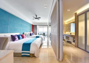 a hotel room with two beds and a television at Lexis Suites Penang in Bayan Lepas