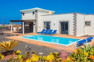 une villa avec une piscine en face d'une maison dans l'établissement Eslanzarote Villa Eleonor, Super Wifi, Heated Pool, Sat tv, à Playa Blanca