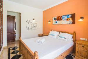 - une chambre dotée d'un lit avec des draps blancs et des murs orange dans l'établissement Eslanzarote Villa Eleonor, Super Wifi, Heated Pool, Sat tv, à Playa Blanca