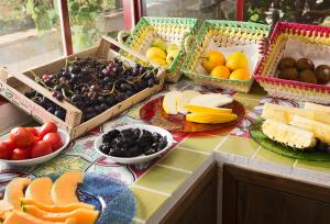 a table topped with baskets of fruits and vegetables at Capri Wine Hotel in Capri