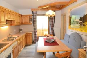 a kitchen with wooden cabinets and a wooden table at Thumeserhof in Schmirn