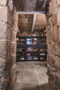 Talbot & Bons Bed & Breakfast في Gudja: غرفة كبيرة مع جدار من زجاجات النبيذ
