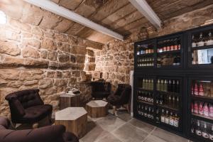 a wine tasting room with wine bottles in a stone wall at Talbot & Bons Bed & Breakfast in Gudja