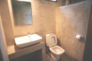 
a bathroom with a toilet, sink, and bathtub at Suan Sook Homestay in Chom Thong
