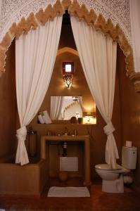 a bathroom with a sink and a toilet and a mirror at Riad Dar Soufa in Rabat