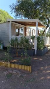 uma pequena casa com plantas em frente em Mobile-Home em Le Muy