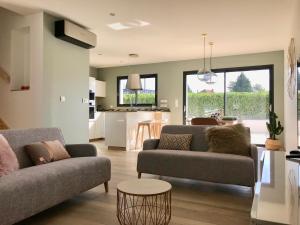 uma sala de estar com dois sofás e uma cozinha em Aux Peupliers de Pradian - Baumier em Bassens