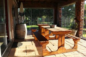 een houten tafel en bank op een patio bij African Adventures Accommodation in Joostenberg Vlakte