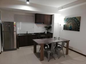 a kitchen with a wooden table and a refrigerator at Seaview Landmark Studio Homestay at Gurney 无敌海景套房 in Tanjong Tokong