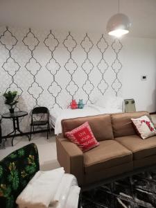 uma sala de estar com um sofá e uma parede em Seaview Landmark Studio Homestay at Gurney 无敌海景套房 em Tanjong Tokong