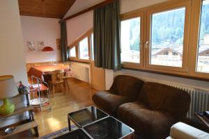 a living room with a leather couch and a table at EMERALD CENTRALE in Madonna di Campiglio