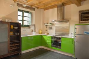 cocina con armarios verdes y nevera en Villa Valedoso en Cabañas