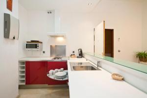 a kitchen with red cabinets and a sink at Logia Sevilla in Seville