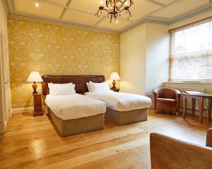 a bedroom with two beds and a chandelier at Moss Grove Organic in Grasmere