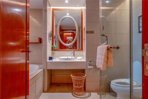 a bathroom with a sink and a toilet and a mirror at Pullman Zhangjiajie Hotel - Instagrammable in Zhangjiajie