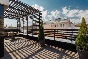 a balcony with a table and chairs on a roof at Il Decameron Luxury Design Hotel in Odesa