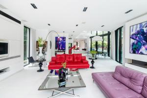 a living room with red couches and a tv at The Mansion by Five Stay in Herzliyya B