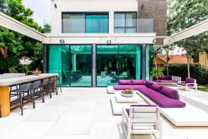 a patio with a purple couch and a table at The Mansion by Five Stay in Herzliya B