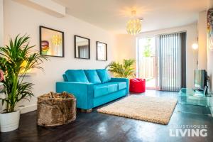 a blue couch in a living room with plants at NEW Spacious Modern Townhouse FREE Private Parking in Liverpool