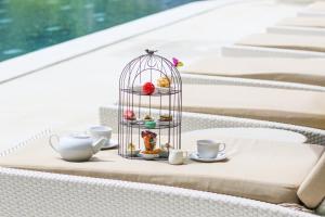a table with a cage filled with pastries and cups at U Khao Yai in Mu Si