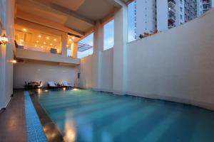 an indoor swimming pool in a building at Starlit Suites Bangalore in Bangalore