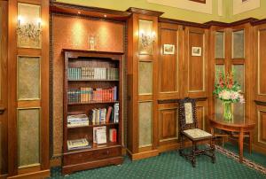 biblioteka z drewnianymi półkami na książki, stołem i krzesłem w obiekcie Hotel Bellevue Wien w Wiedniu