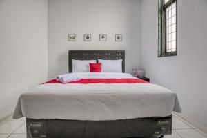 a bedroom with a large bed with red pillows at RedDoorz Plus near Jakarta Kota Station in Jakarta