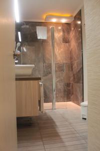 a bathroom with a shower with a sink and a toilet at Tempo Residence Comfort Izmir in İzmir