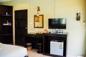a room with a tv and a desk with a television at Lanta Castaway Beach Resort in Ko Lanta