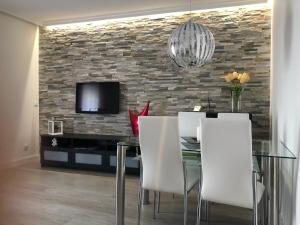 a dining room with a glass table and white chairs at Casa Palacio Polentinos VUT-AV390 in Ávila