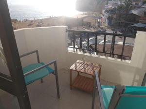 カルヴォエイロにあるApartamento na Praiaのバルコニー(椅子、テーブル付)、ビーチが備わります。