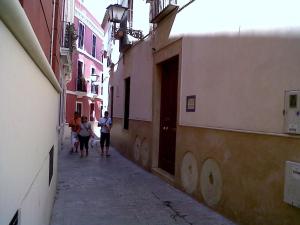 a group of people walking down a narrow alley at Logia Sevilla in Seville