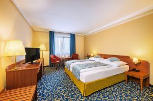 pokój hotelowy z łóżkiem i telewizorem z płaskim ekranem w obiekcie Hotel Bellevue Wien w Wiedniu +25 zdjęć