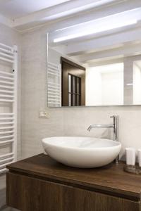 La salle de bains est pourvue d'un grand lavabo blanc et d'un miroir. dans l'établissement Rialto Corte dei Sansoni canal view, à Venise