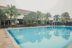 占碑市RedDoorz Syariah @ Pasir Putih Jambi的建筑物前的一个大型蓝色游泳池