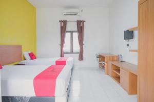 Postel nebo postele na pokoji v ubytování RedDoorz Syariah @ Pasir Putih Jambi + 11 fotografií