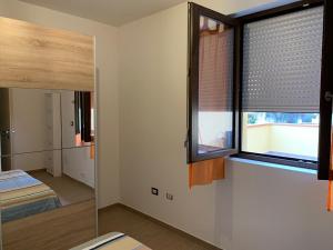 ポルト・トッレスにあるEma Homeの窓と鏡付きのベッドルーム1室