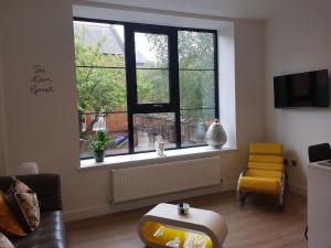 ein Wohnzimmer mit einem großen Fenster und einem Stuhl in der Unterkunft 34 Cuppin Street - luxury city centre apartment! in Chester