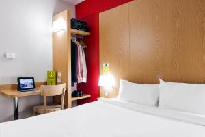 a bedroom with a bed and a desk with a laptop at B&B HOTEL Toulouse Purpan Zénith in Toulouse