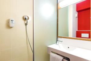 a bathroom with a shower and a sink and a mirror at B&B HOTEL Toulouse Purpan Zénith in Toulouse