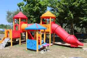 un parque infantil con un tobogán y un tobogán en Happy Camp Mobile Homes in Camping Cisano San Vito en Bardolino