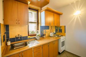 a kitchen with wooden cabinets and a sink at Privát NA CHALUPE Partizánska Ľupča 649 in Partizánska ľupča