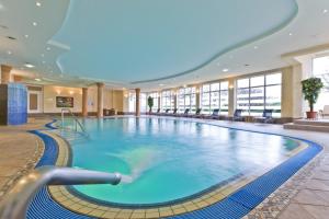 a large swimming pool in a hotel lobby at Aparthotel Treudelberg in Hamburg