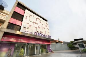 a building with a pink and white building at Super OYO Capital O 136 Manggis Inn in Jakarta