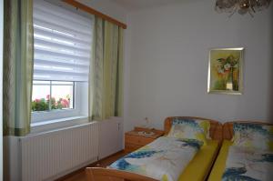 a small bedroom with a bed and a window at Ferienwohnung Birgit in Eisenstadt