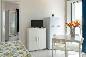 d'une salle à manger avec une table et un réfrigérateur. dans l'établissement Centro Vacanze Lido Smeraldo, à Frigole