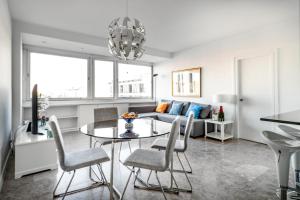 sala de estar con mesa, sillas y sofá en Urbantec Realty - Plaza de Colón, en Madrid