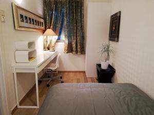 um quarto com uma cama, uma secretária e uma janela em The Little Apartment em Sola