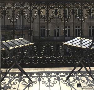 zwei Bänke auf einem Zaun vor einem Gebäude in der Unterkunft Etoile Park Hotel in Paris