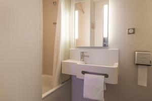 a bathroom with a white sink and a mirror at B&B HOTEL Troyes Barberey in Barberey-Saint-Sulpice
